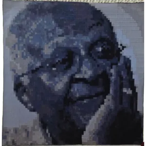 Dana Biddle — Wisdom (Desmond Tutu). A portrait made from 1cm squares of hand dyed fabric stitched on canvas, in layered blues and greys. 1m x 1m. Sold to the Michigan State University Museum of Art.